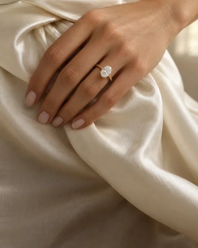 A hand wearing stacked diamond rings, a pear and a radiant